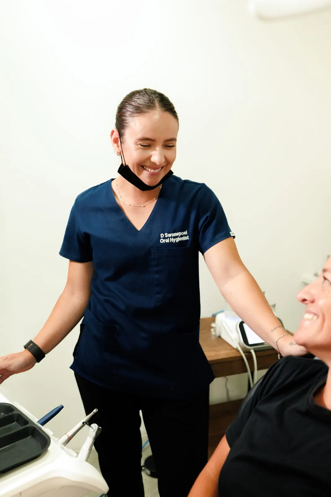 Oral hygienist smiling with a patient in the chair