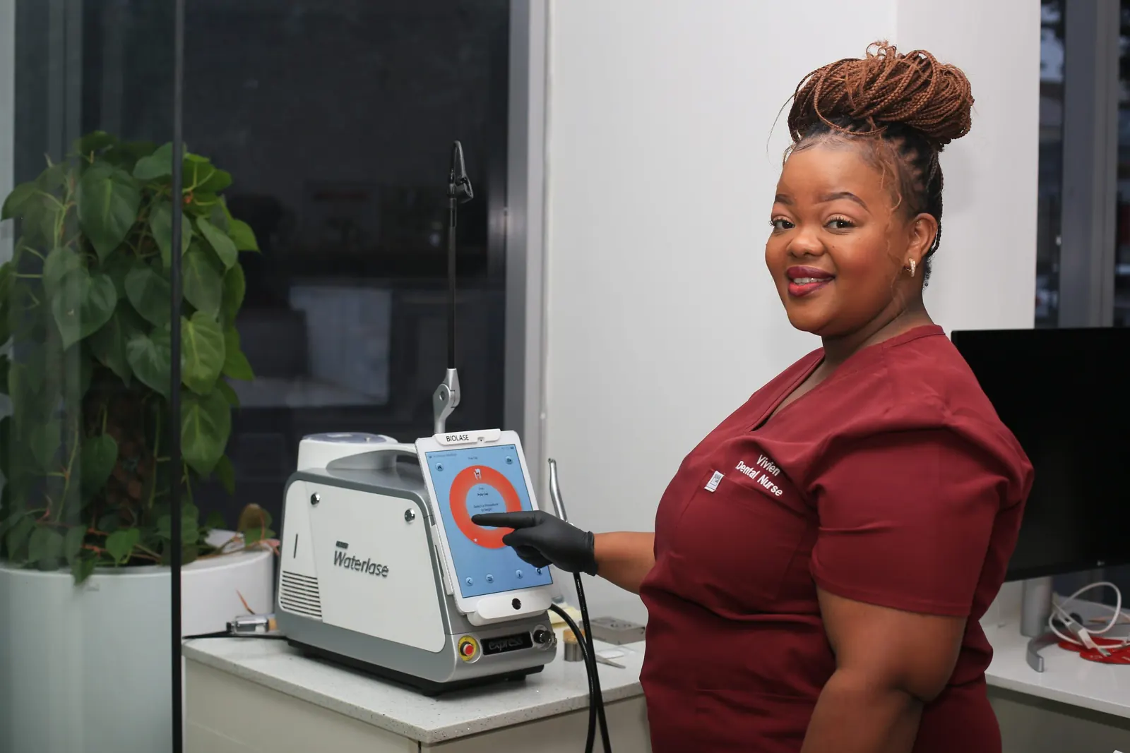 Dental nurse beside the practice's dental laser