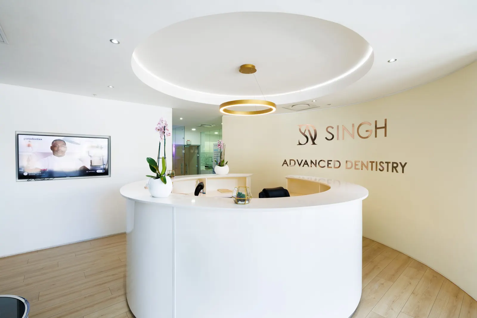 The curved white reception desk below the Singh logo