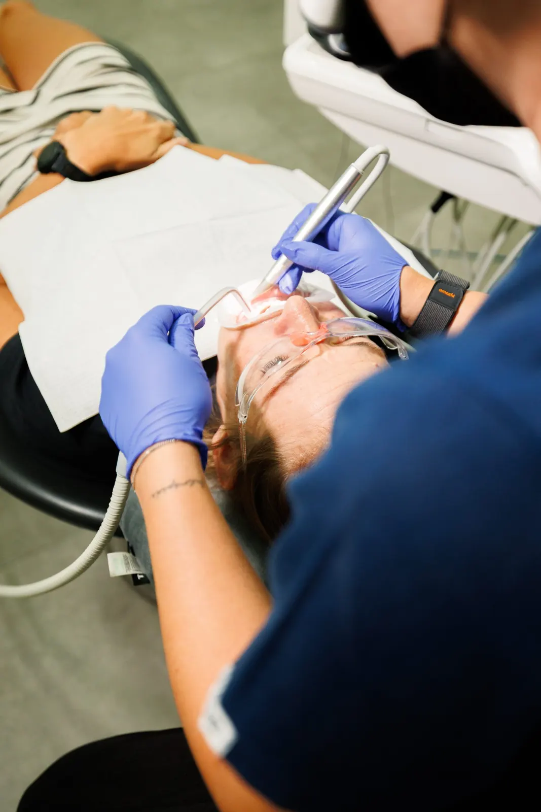 Close-up of a hygiene treatment, with the patient wearing protective glasses