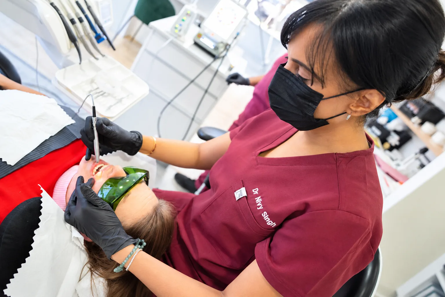 Dr Nivy Singh carrying out a laser treatment, with the patient wearing protective glasses